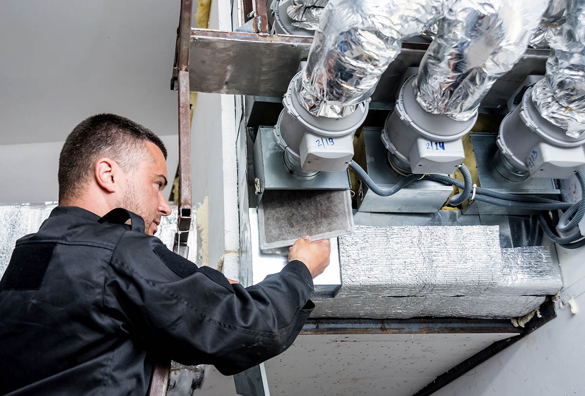 Technicien inspectant un système de conduits de ventilation