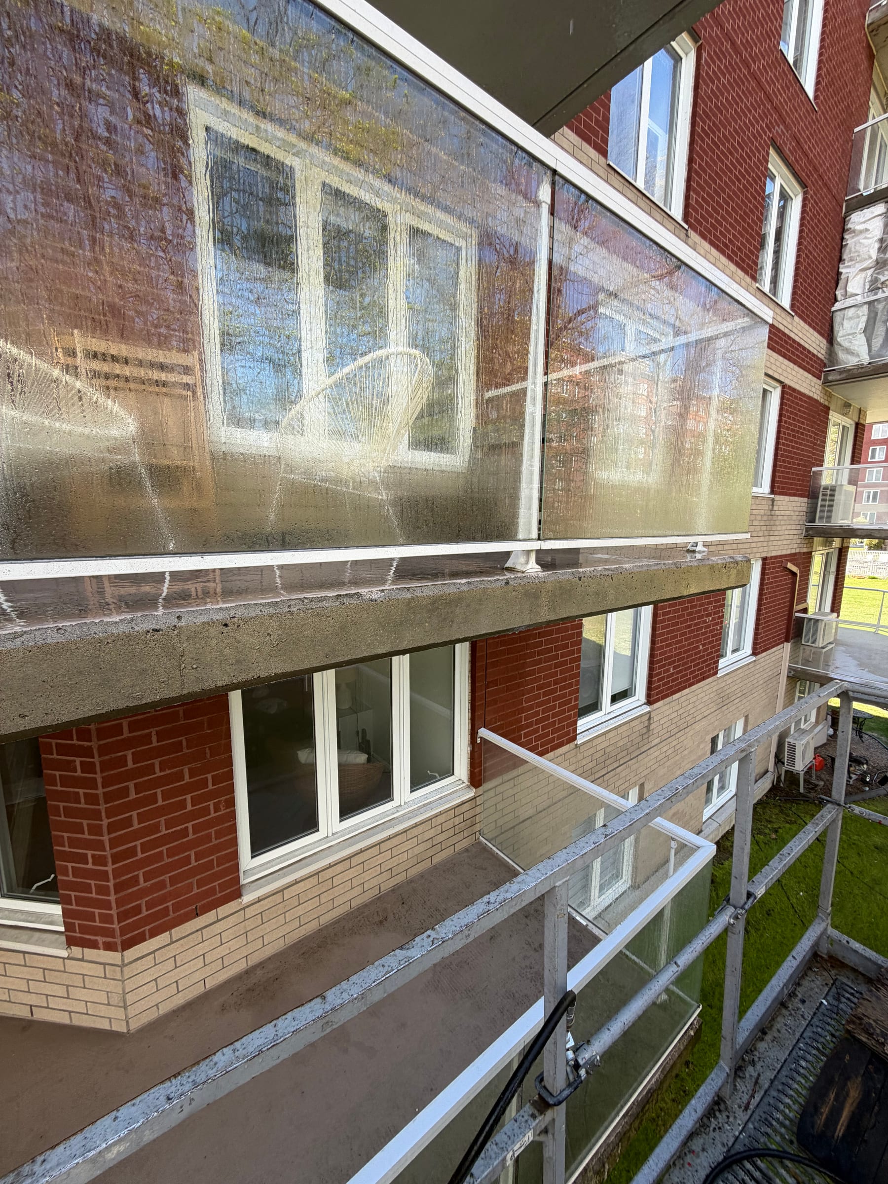 Rebord de balcon et panneaux vitrés après le nettoyage à pression