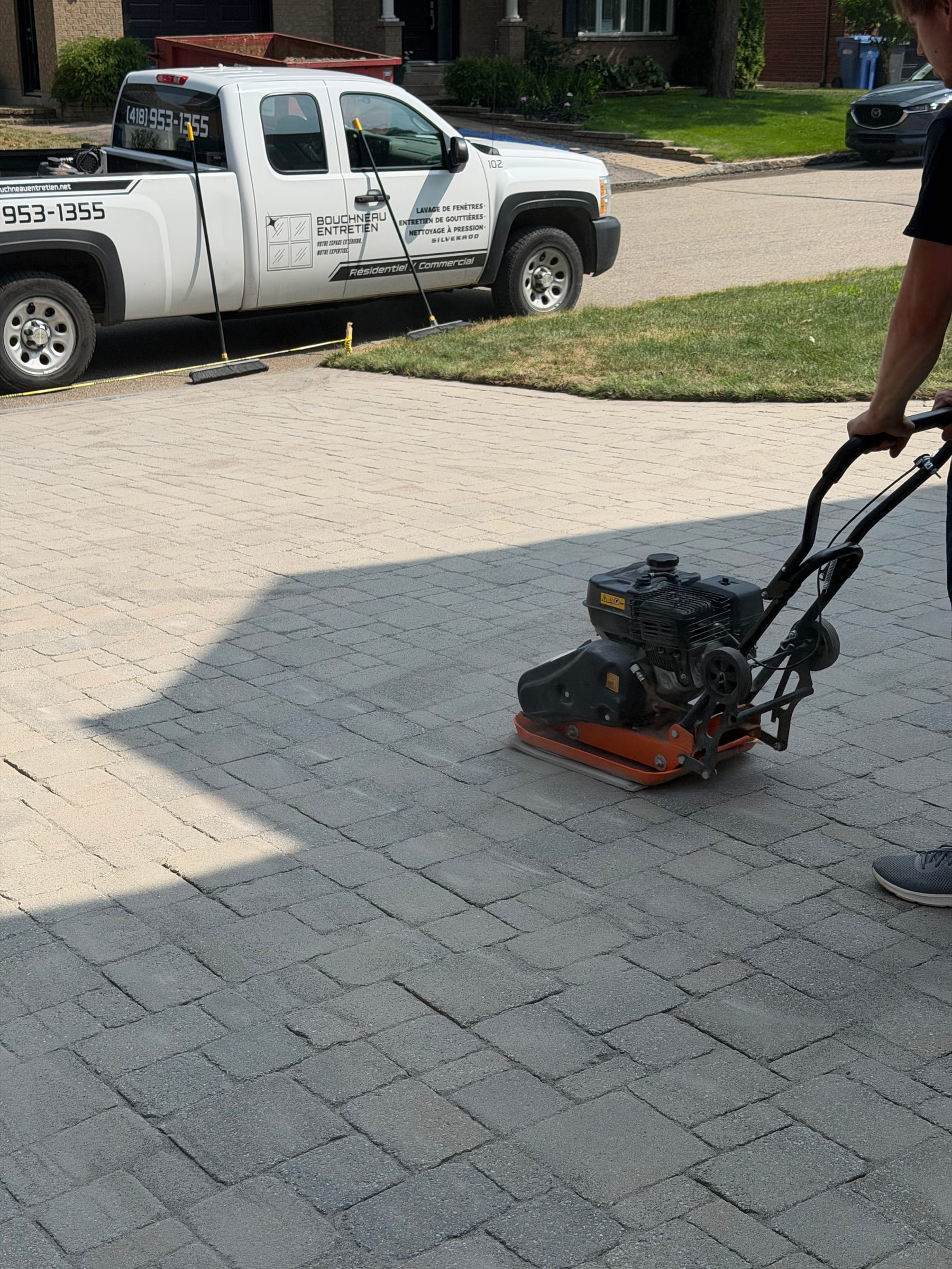 Technicien Bouchneau compactant une entrée en pavé lors d’un rejointement au sable polymère